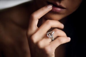 Traveler places individual rings, earrings, and a necklace into a compartmented jewelry case.
